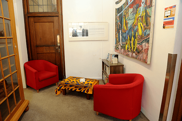 rwading corner with red tub chair and painting on the wall