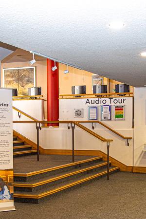 View of Main Library Foyer displaying rollup banners, TV and stairs leading up to the Hub